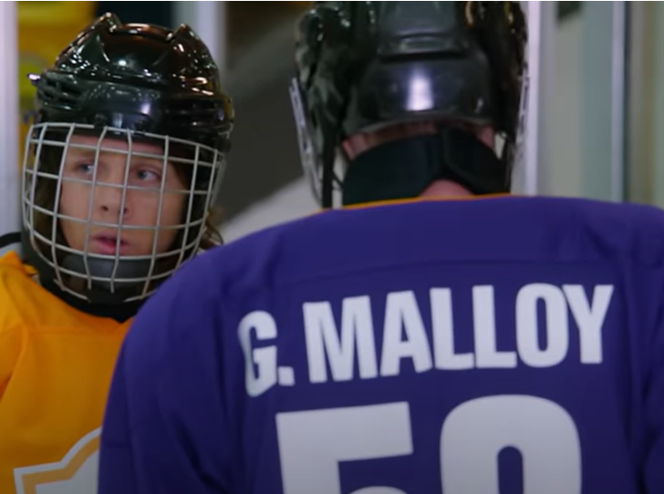 Dos chicos con equipación de hockey. El más joven mira al infinito con cara de susto.